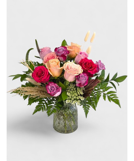 Vintage Garden style roses designed in a pink dimple pattern Vase. Antique hues of Lavender, pink and cream Roses mixed with seasonal cut garden accents. 