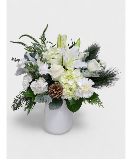 A beautiful mix of roses, lilies, and hydrangea with delicate filler flowers, designed in a clear cube vase.