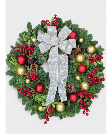 This festive Northwest-style wreath features a lush, full base of evergreen branches in varying textures, including noble fir, cedar, and other seasonal greenery