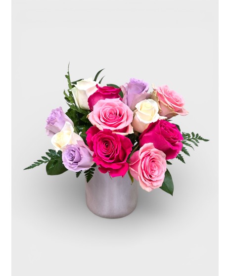 Vintage Garden style roses designed in a pink dimple pattern Vase. Antique hues of Lavender, pink and cream Roses mixed with seasonal cut garden accents. 