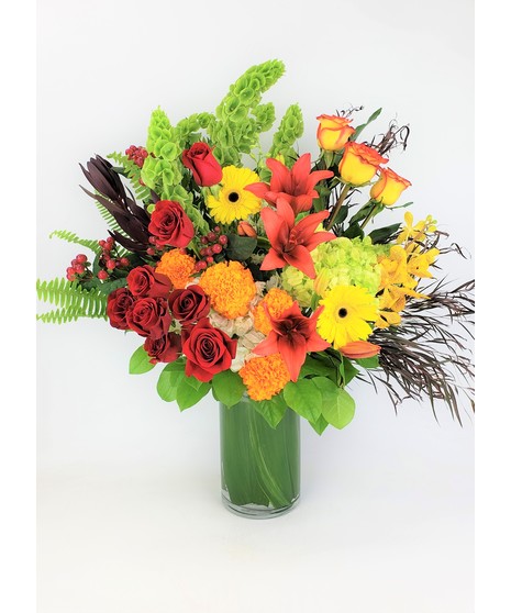 Send pure elegance with this bold mix of textures and orange, yellow and green that includes lilies, roses, Hydrangea and other floral textures.