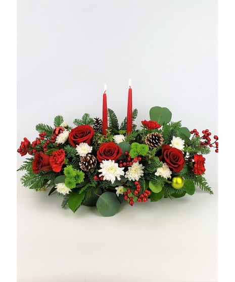 Double candle centerpiece featuring red roses, tartan ribbon, and other festive flowers. 