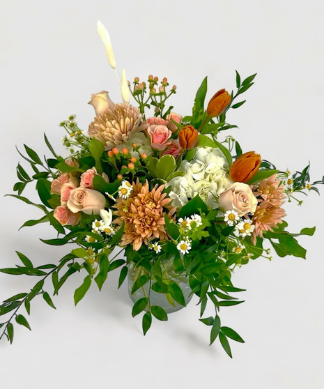 fall-toned floral arrangement in winking head-shaped container