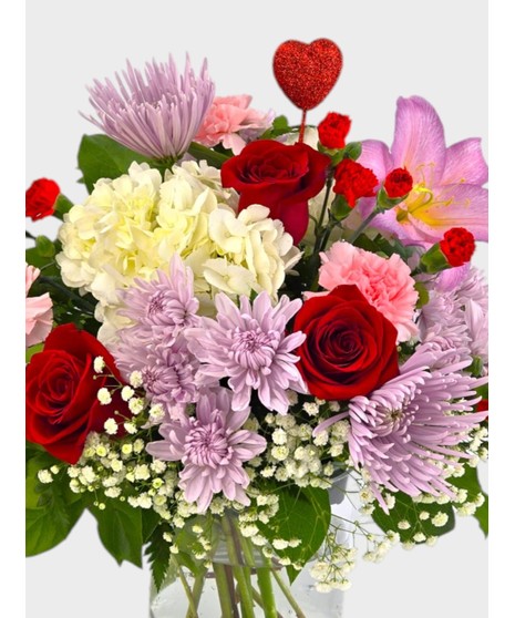 This mix of red roses, mums, carnations, stock, and assorted fillers is accented by a sparkling red heart.  A perfect gift for your Valentine!