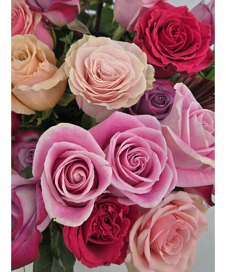 Vintage Garden style roses designed in a pink dimple pattern Vase. Antique hues of Lavender, pink and cream Roses mixed with seasonal cut garden accents. 