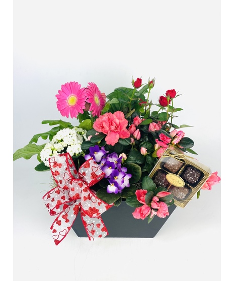 A black wooden box with bright blooming plants and handmade Sea Salt Caramels will leave a lasting impression. 