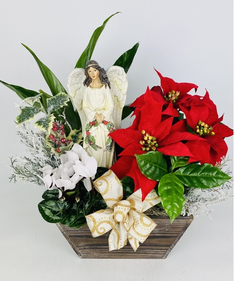 A rustic wood box filled with festive blooming plants, other seasonal decor and a beautiful winter keepsake angel. 
