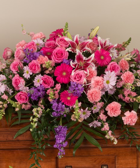A soft mix of roses, lilies, and daisies in shades of pink and lavender. 
