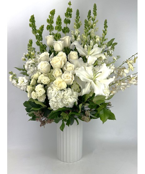 Send all of your Best wishes with this beautiful white and green design which features hydrangea, roses and fragrant lilies in our leaf-wrapped signature clear vase.