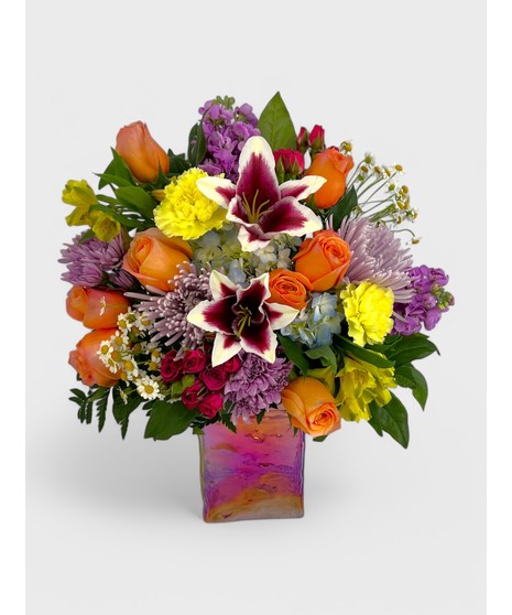Mixed pastel shades of Hydrangea, Carnations, Mums and other fresh florets in a botanical tin vase. 