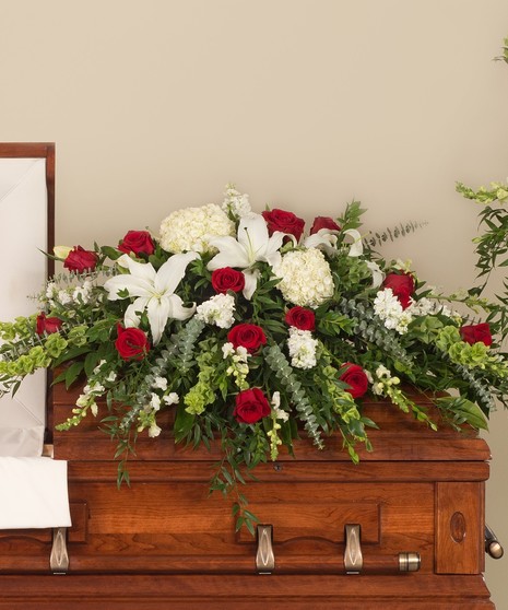 Classic casket designed with a mix or premium red and white flowers including hydrangea, roses, and lilies.