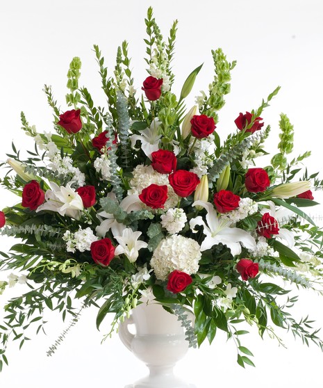 Stunning mix of red roses and white lilies designed in a white container. Approximate size for the standard design is 20