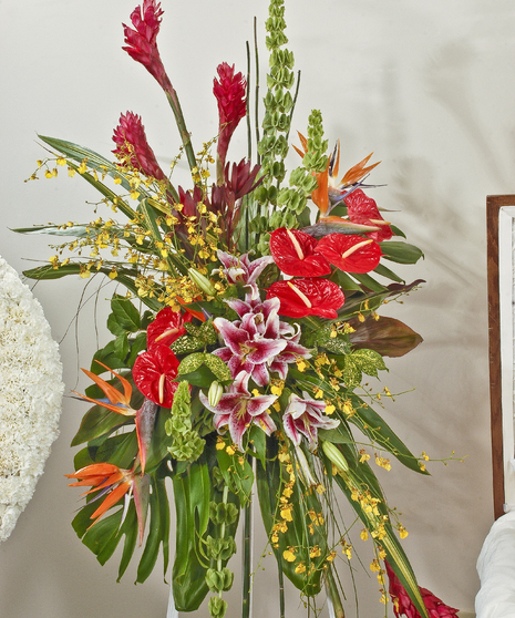 Tropical easel spray featuring lilies, orchids, Ginger and other tropical accents. Approximate size of the standard design is 28