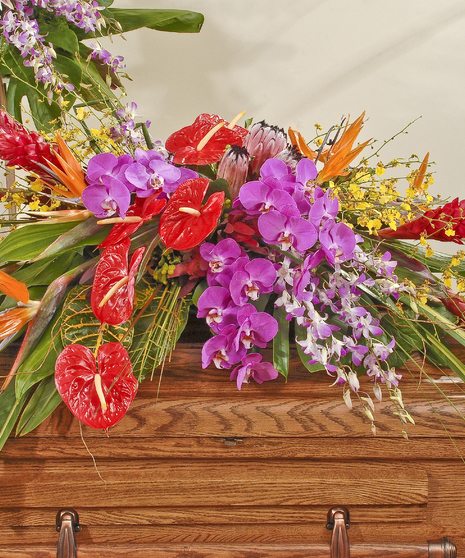 Tropical casket spray featuring exotic orchids, Anthurium,birds of paradise and other tropical flowers surrounded by lush tropical greens. 
