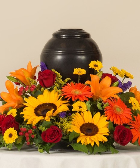 Tuscan Mix of roses, sunflowers, lilies, and other accenting flowers. Creating a vibrant and beautiful place for a memorial urn. Memorial Urn not included.