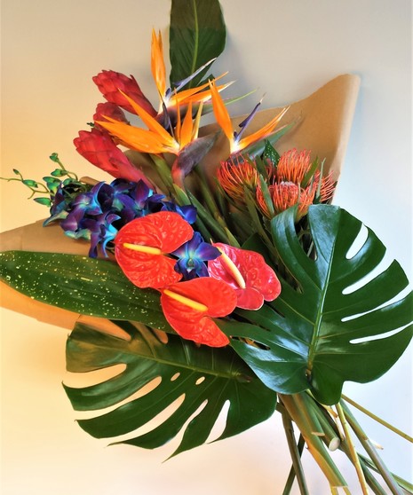 Tropical Ginger , orchids & Antherium design complimented with tropical foliage. Send a beautifully crafted Keepsake vase with fresh tropical flowers.